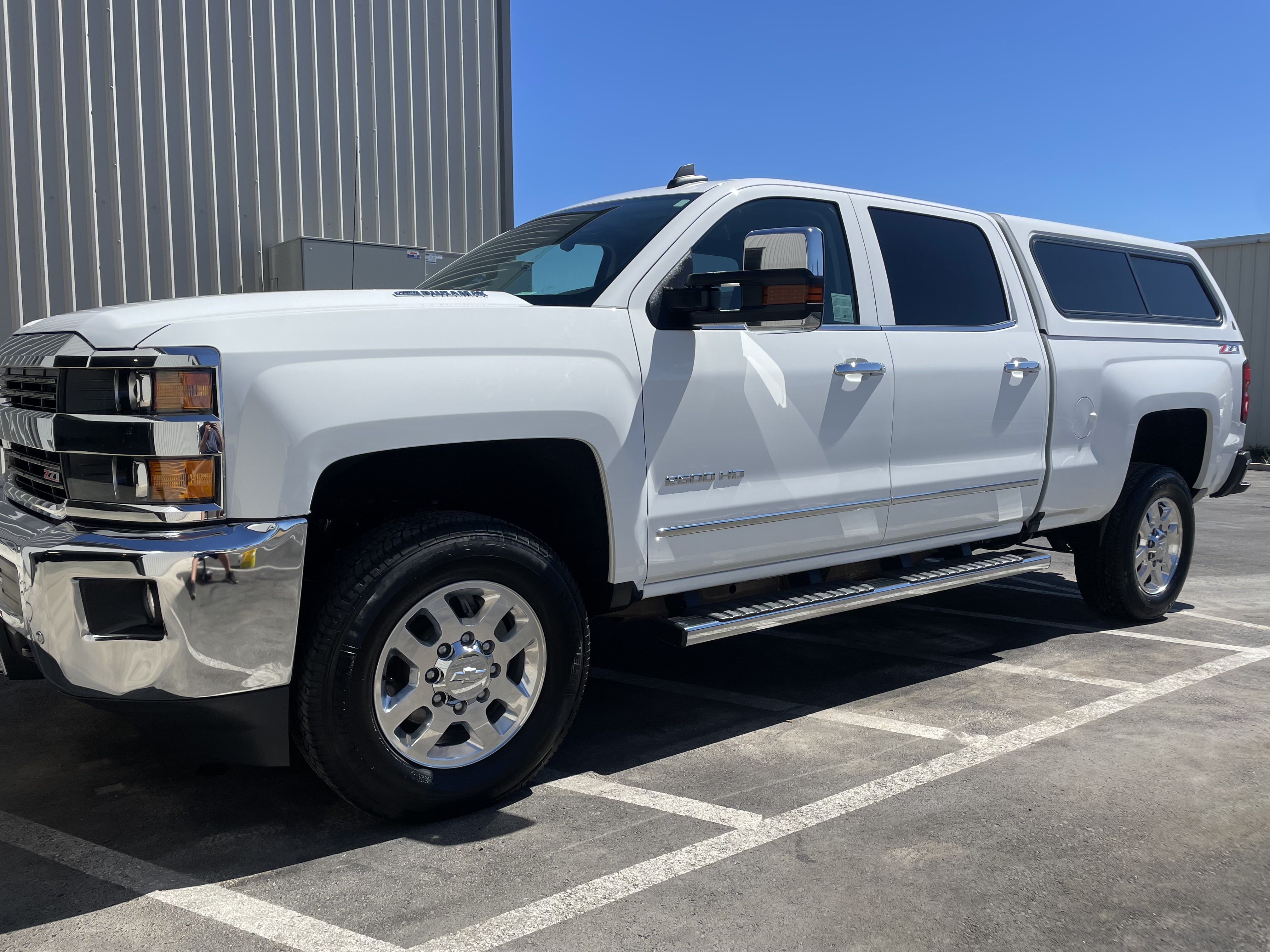 White work truck after exterior detailing with a brighter paint finish and cleaner wheels.